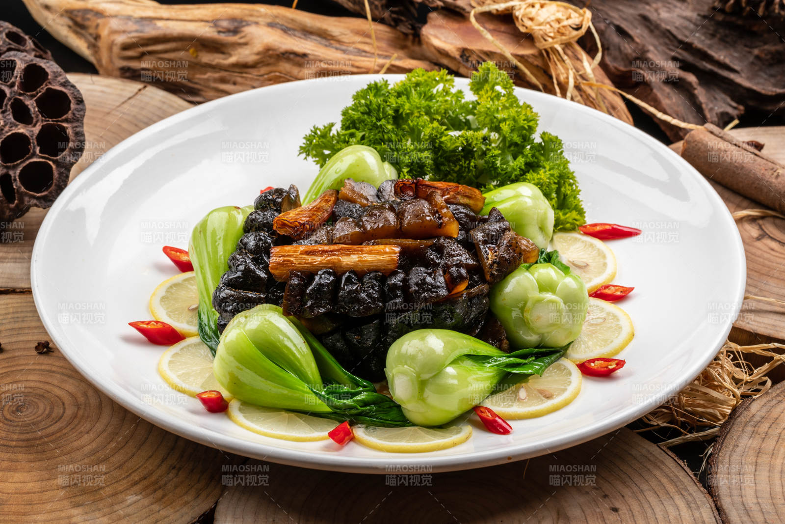 花式摆盘的葱烧大海参摆放在樟木砧板上图片