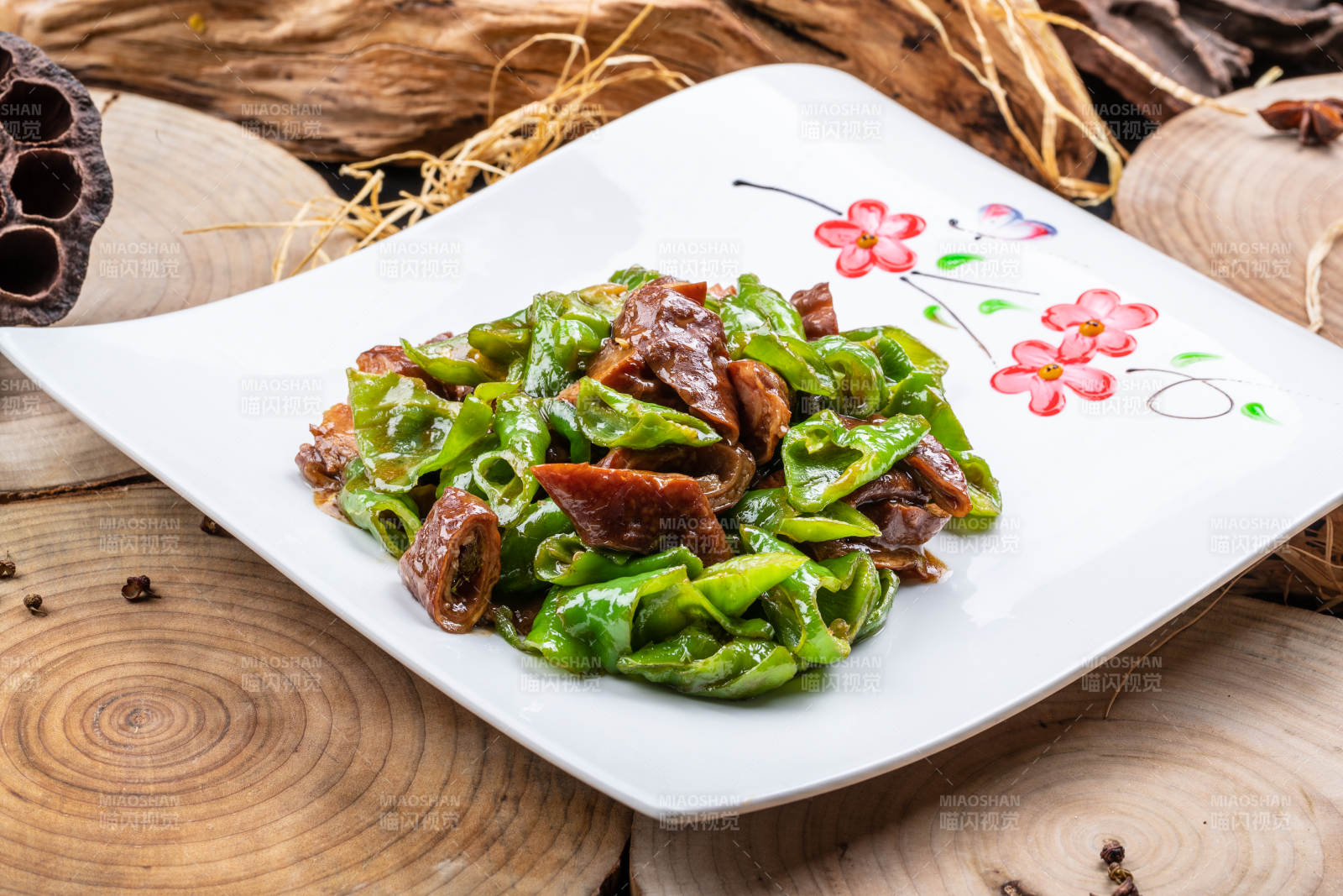 尖椒烧肥肠摆放在樟木砧板上图片