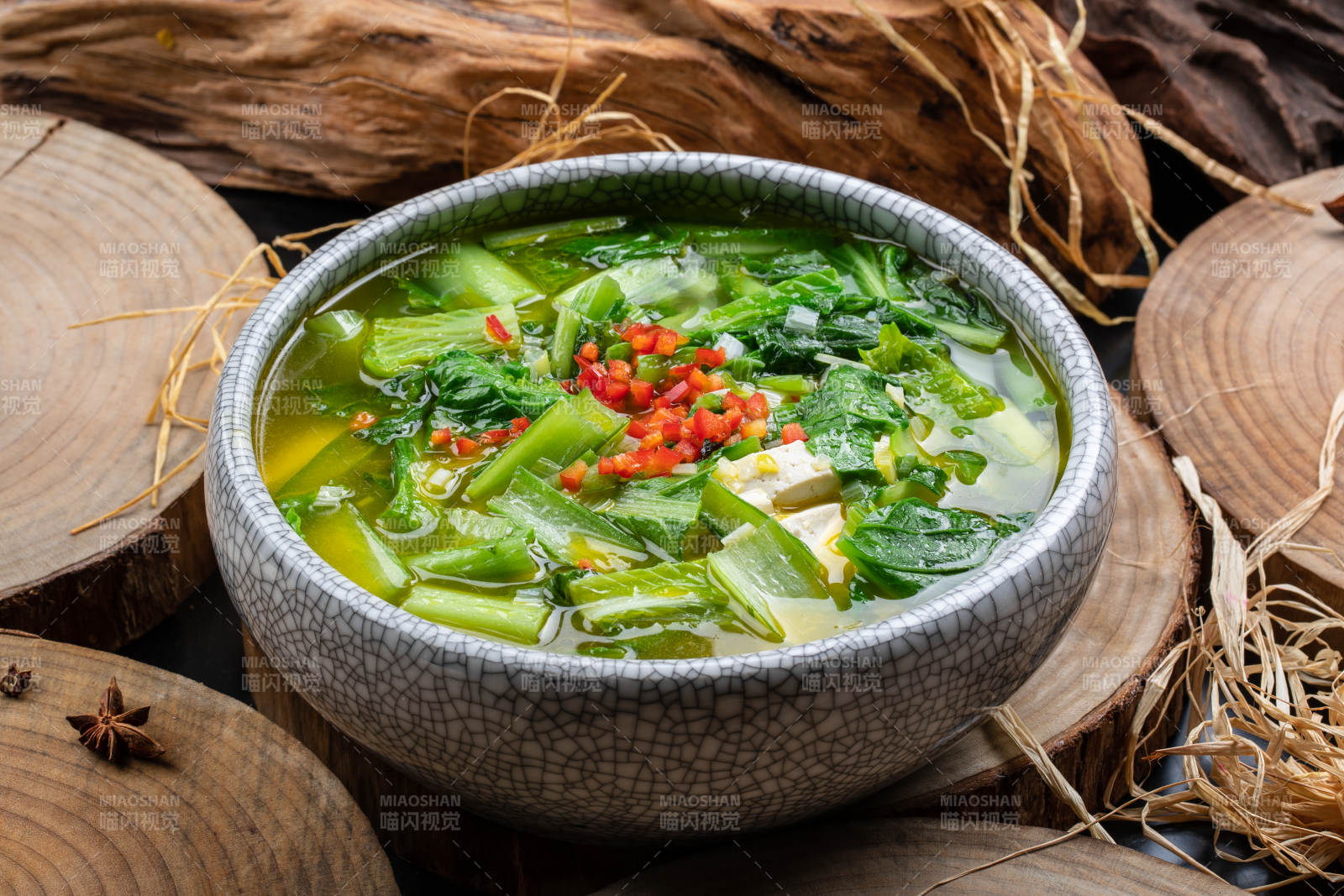 开片瓷碗装的小白菜烧豆腐摆放在樟木砧板上图片