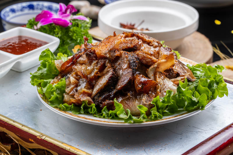 红漆木板装的分切全羊肉摆放在樟木砧板上图片