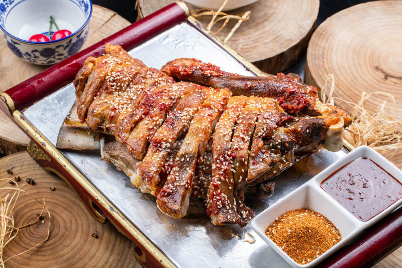 塞外草原烤羊腿摆放在樟木砧板上图片