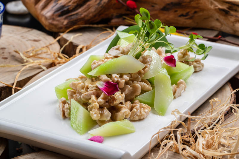 白瓷盘装的西芹鲜桃仁图片