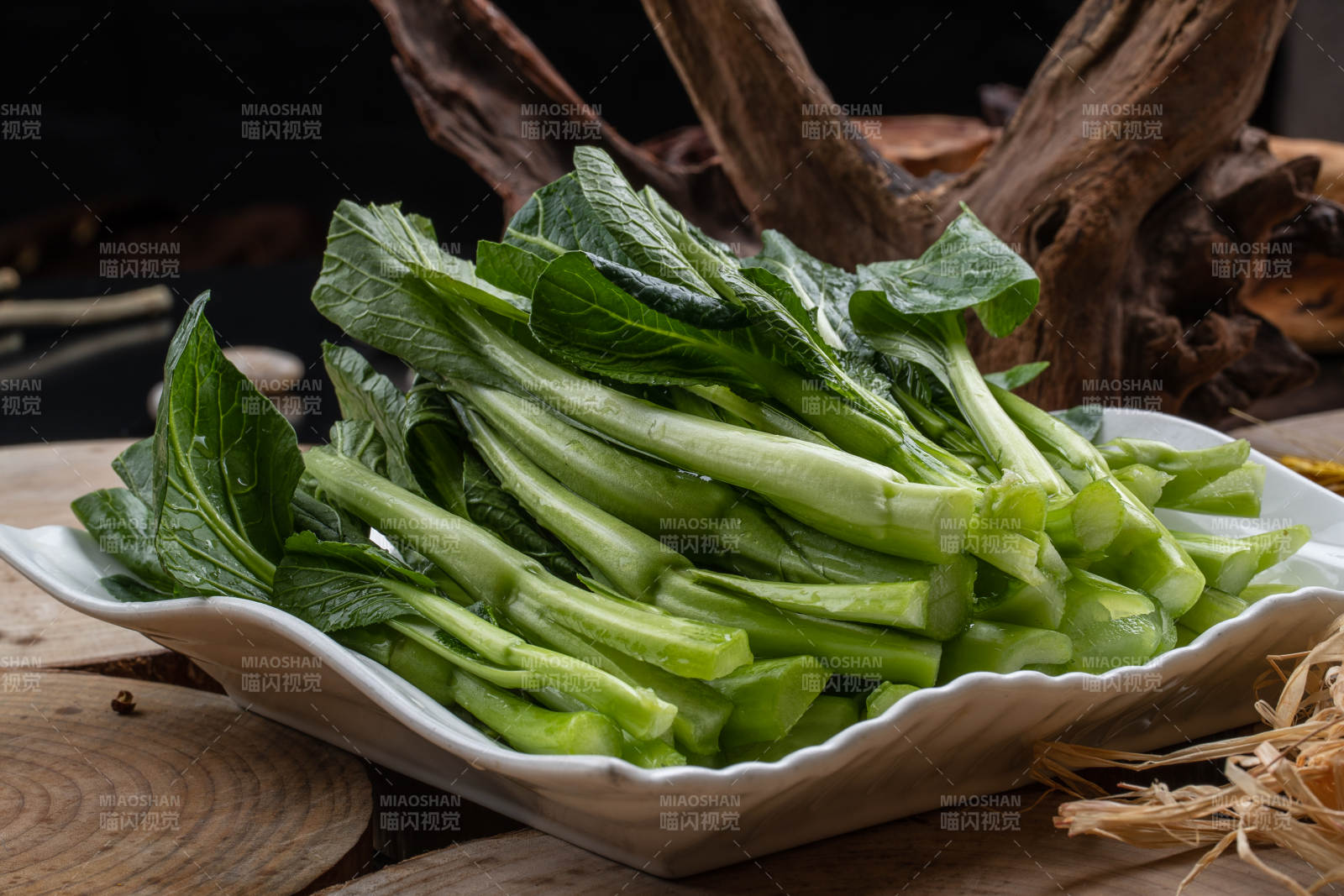 白色瓷盘装的生鲜新鲜菜心图片