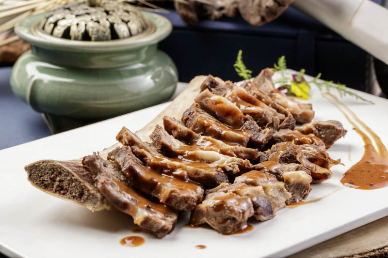 黑胡椒酱汁牛肋剔骨肉摆放在樟木砧板上图片