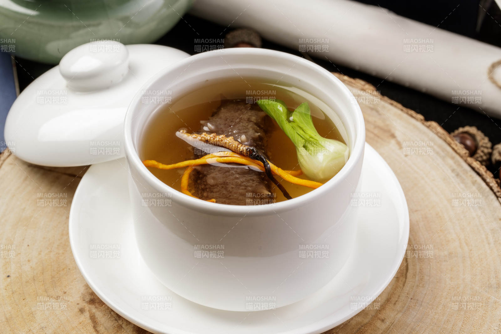 滋补虫草花海参汤摆放在樟木砧板上图片