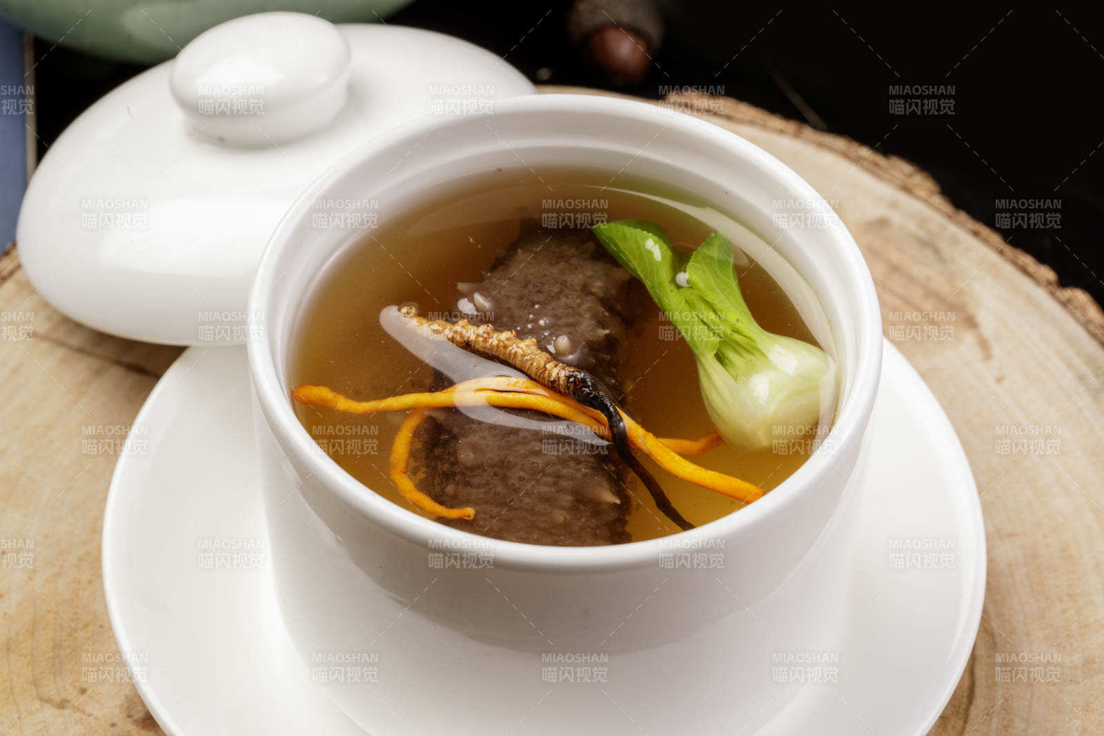 滋补虫草花海参汤摆放在樟木砧板上图片