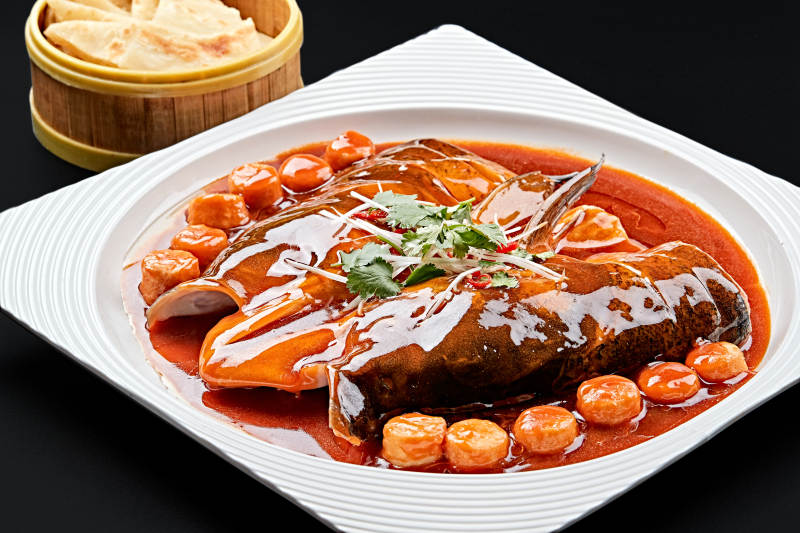 白色瓷盘装的红烧千岛湖大鱼头图片