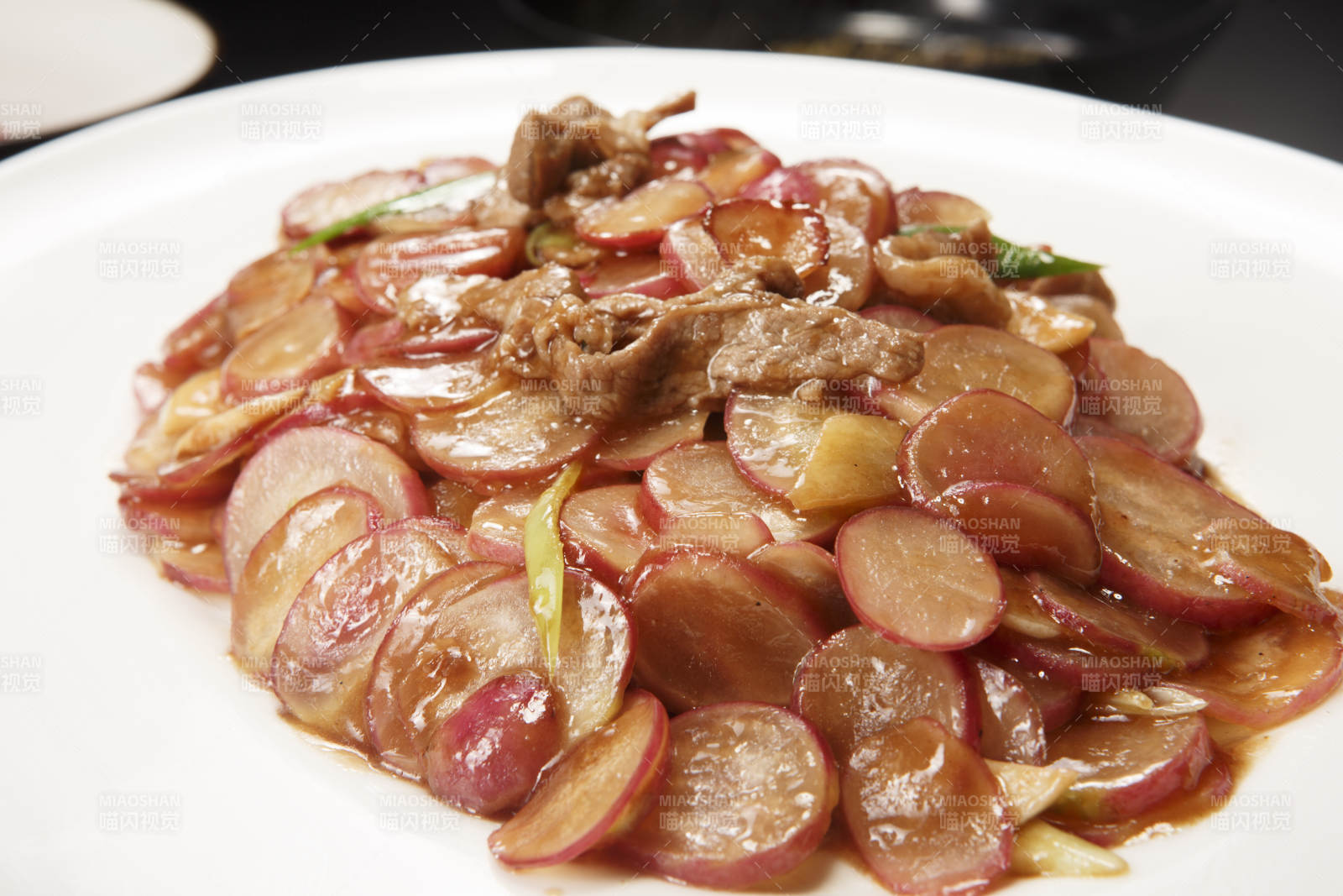白色瓷盘装的五花肉炒水萝卜图片