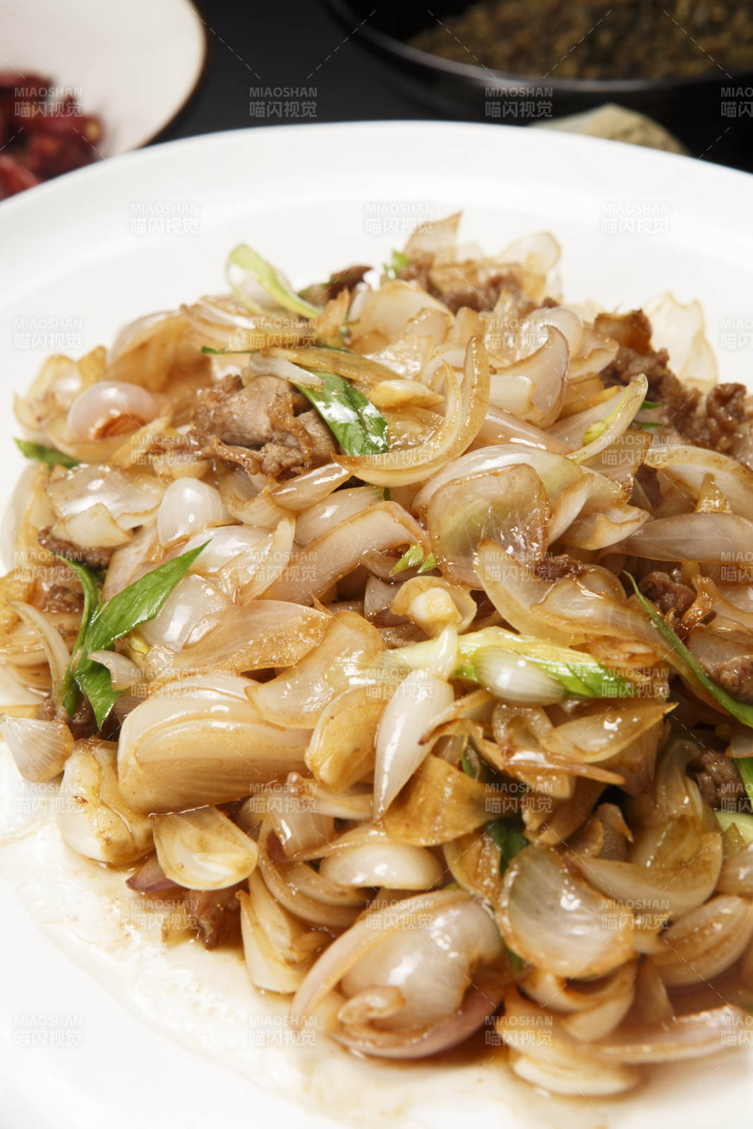 白色圆盘装的肉炒百合图片