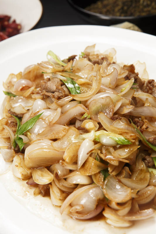 白色圆盘装的肉炒百合图片