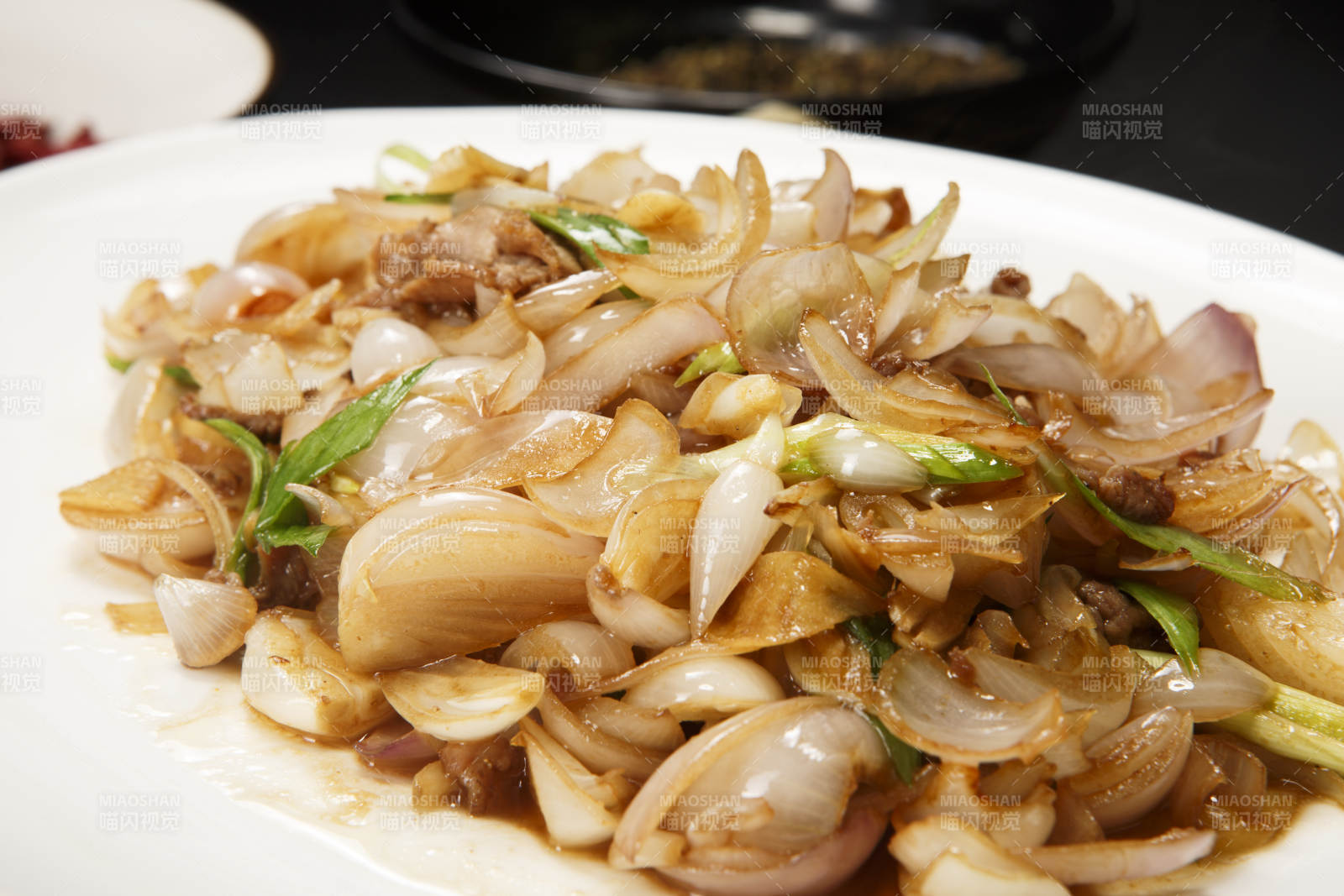 白色圆盘装的肉炒百合图片