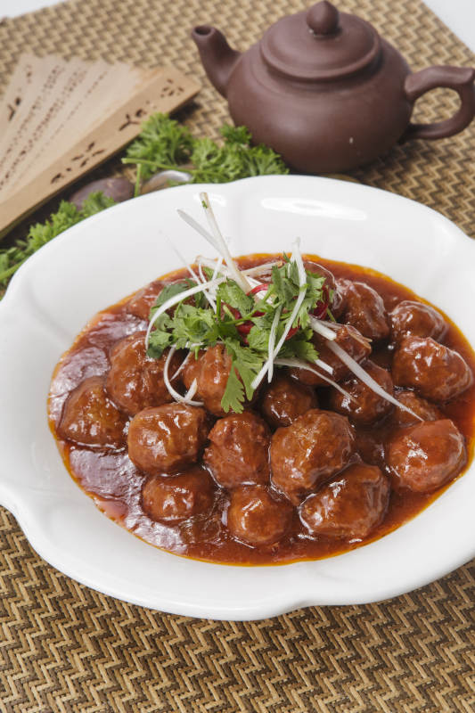 白色瓷盘装的红烧丸子图片