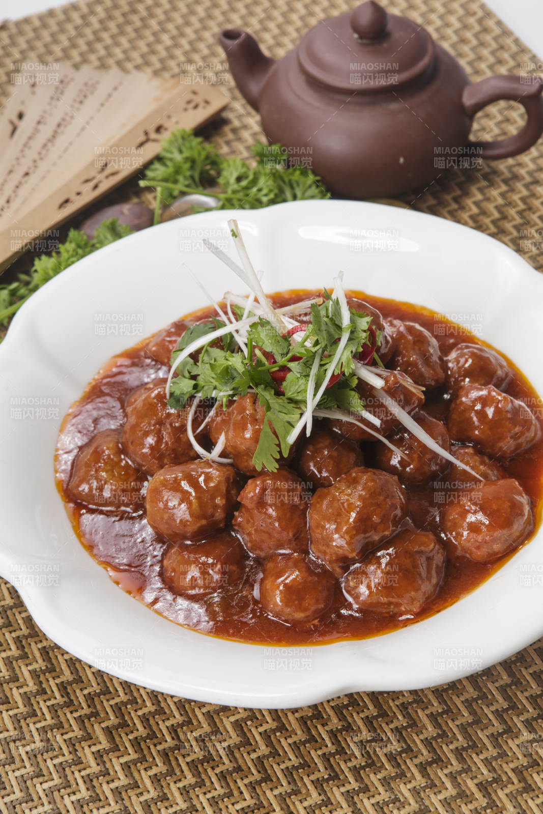 白色瓷盘装的红烧丸子图片