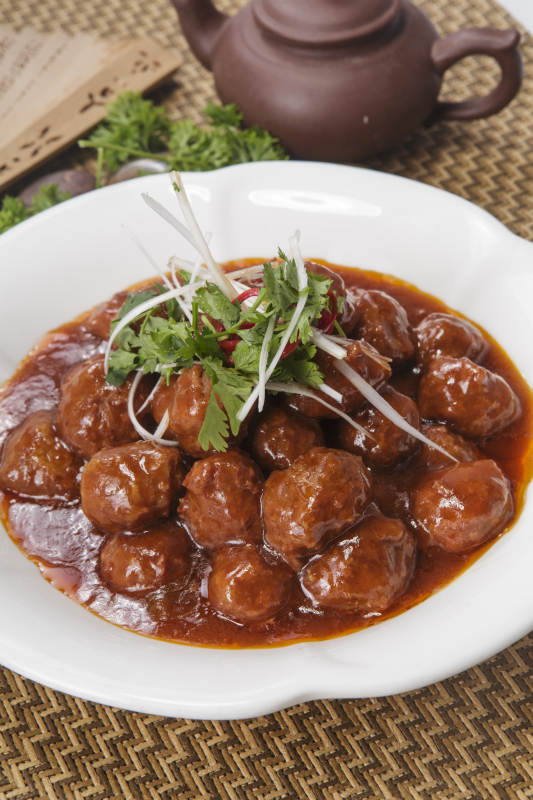 白色瓷盘装的红烧丸子图片