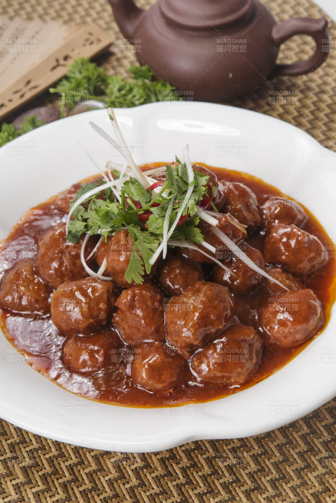 白色瓷盘装的红烧丸子图片