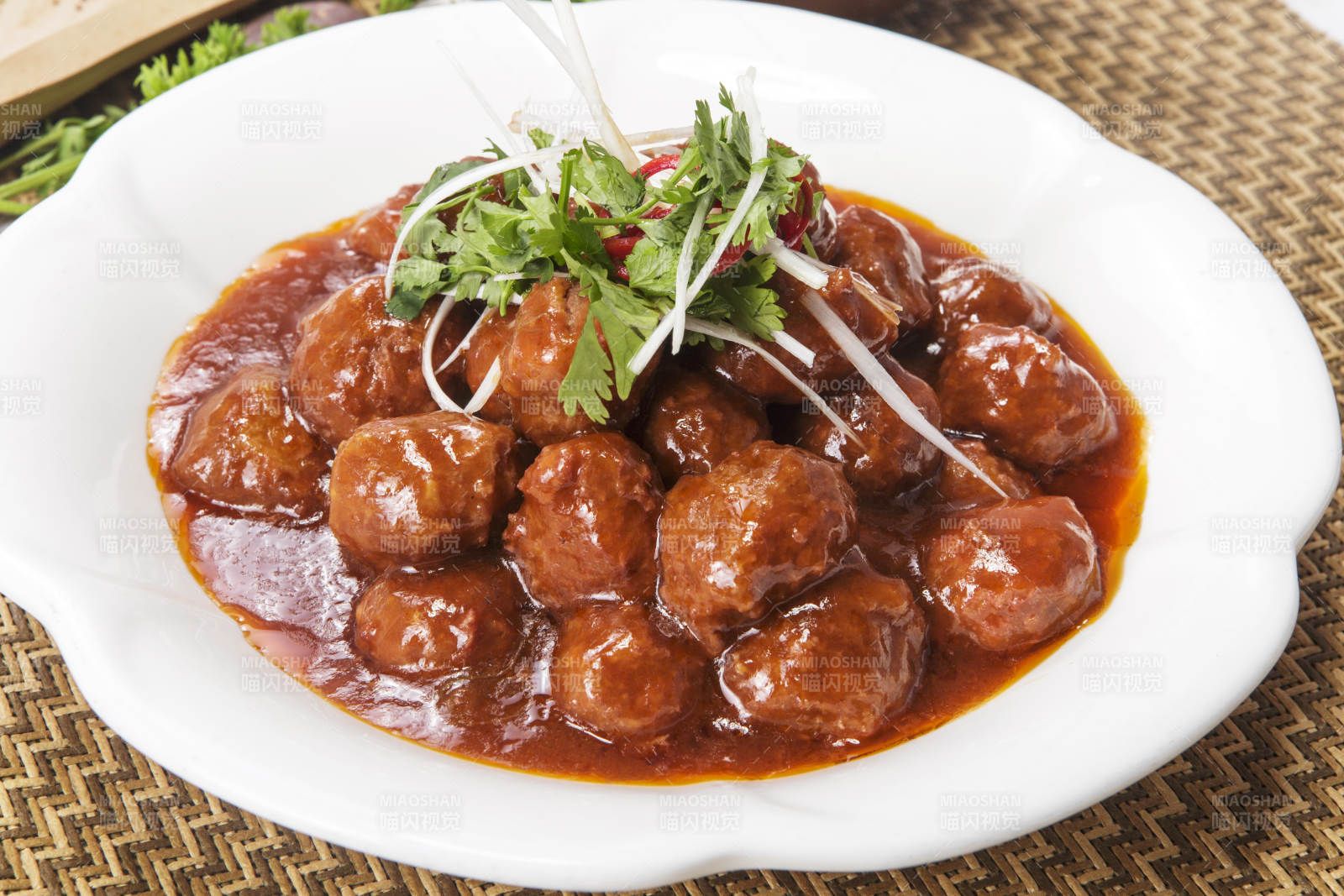 白色瓷盘装的红烧丸子图片