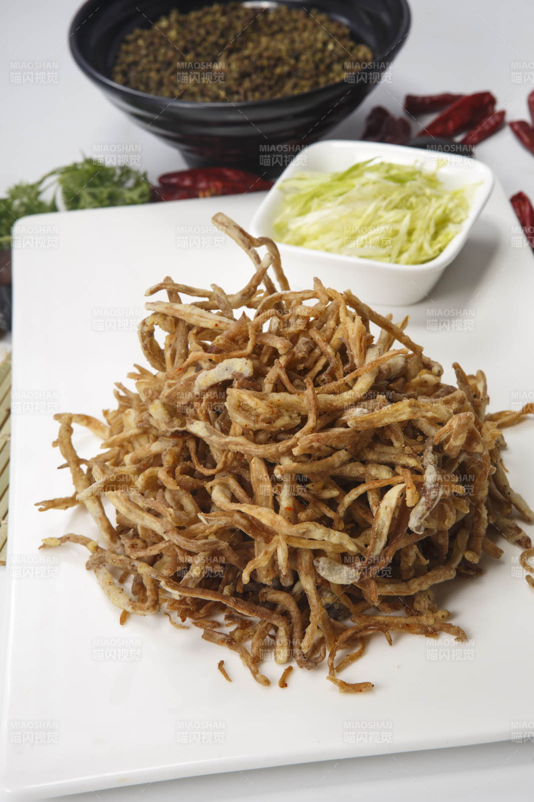 白色瓷盘装的香酥茶树菇图片