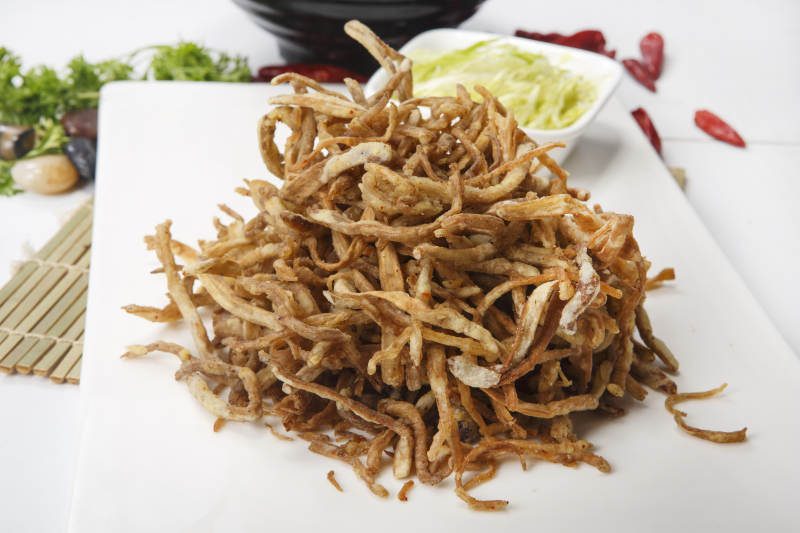 白色瓷盘装的香酥茶树菇图片