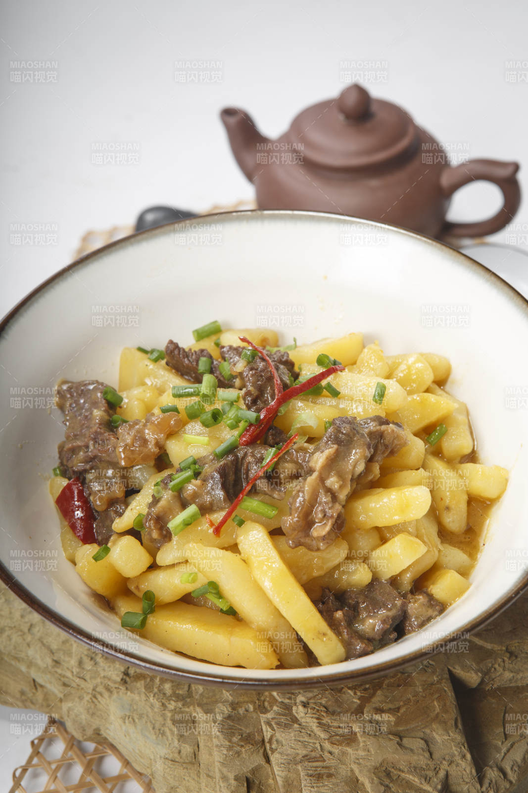 白色瓷碗装的牛腩烧土豆图片