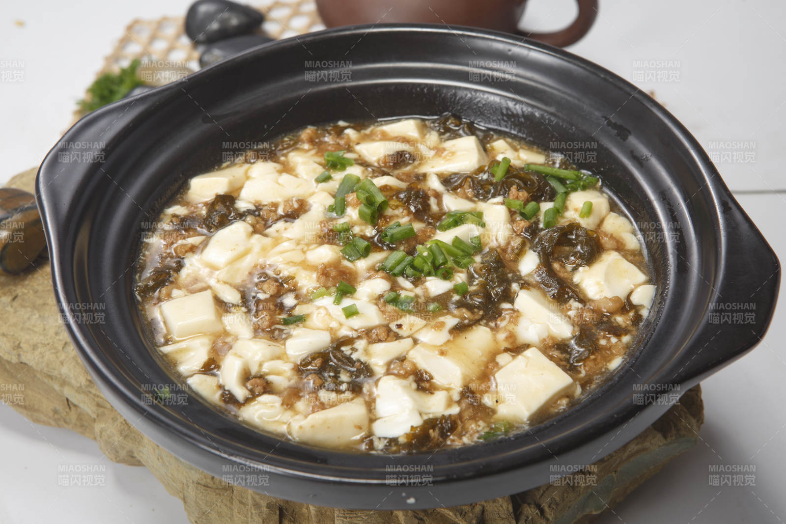 黑色砂锅装的酸豆角豆腐煲图片