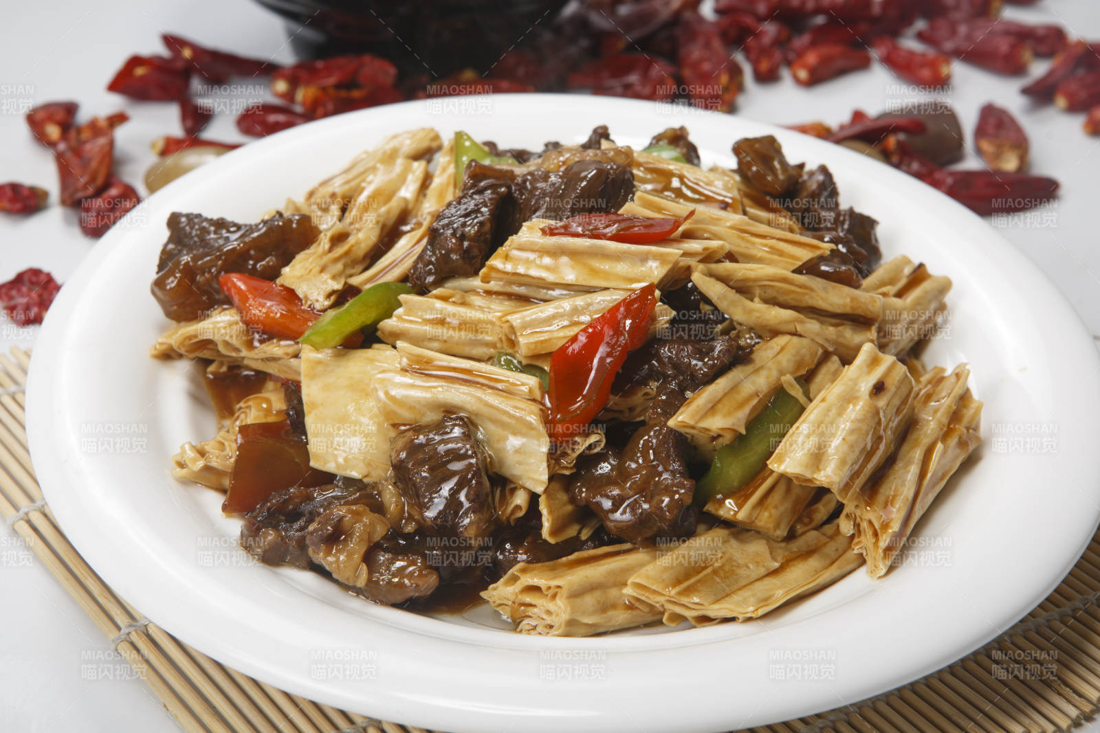 白色圆瓷盘装的牛腩烧腐竹图片