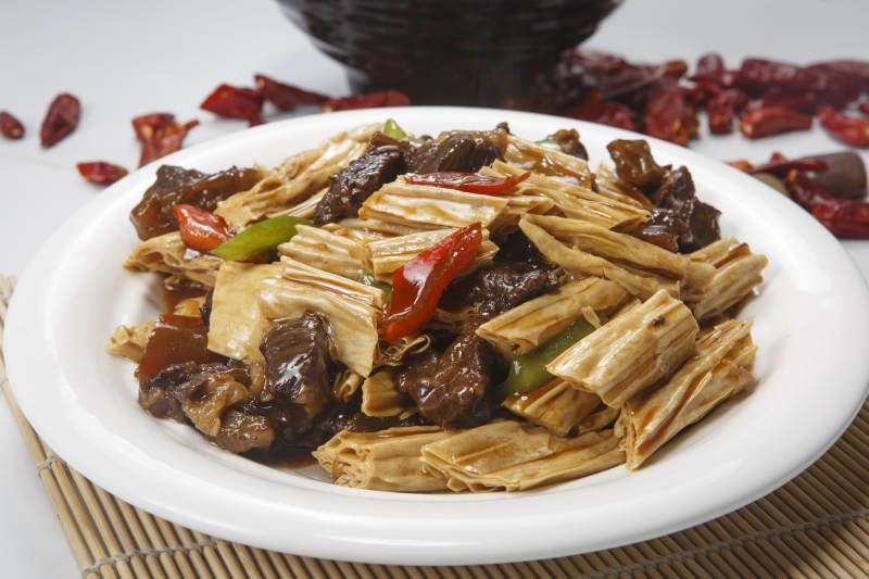 白色圆瓷盘装的牛腩烧腐竹图片