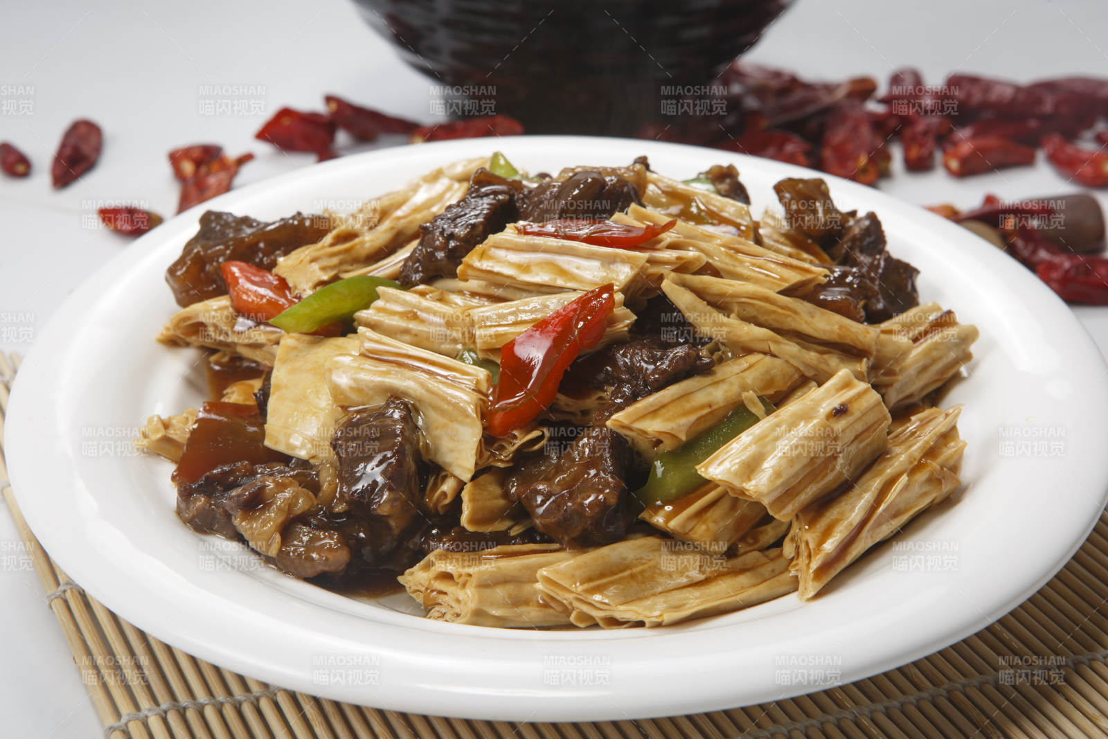 白色圆瓷盘装的牛腩烧腐竹图片