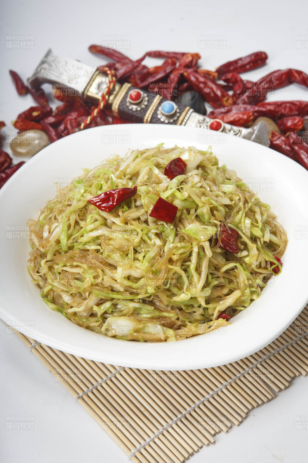 白瓷盘装的粉丝炒包菜图片