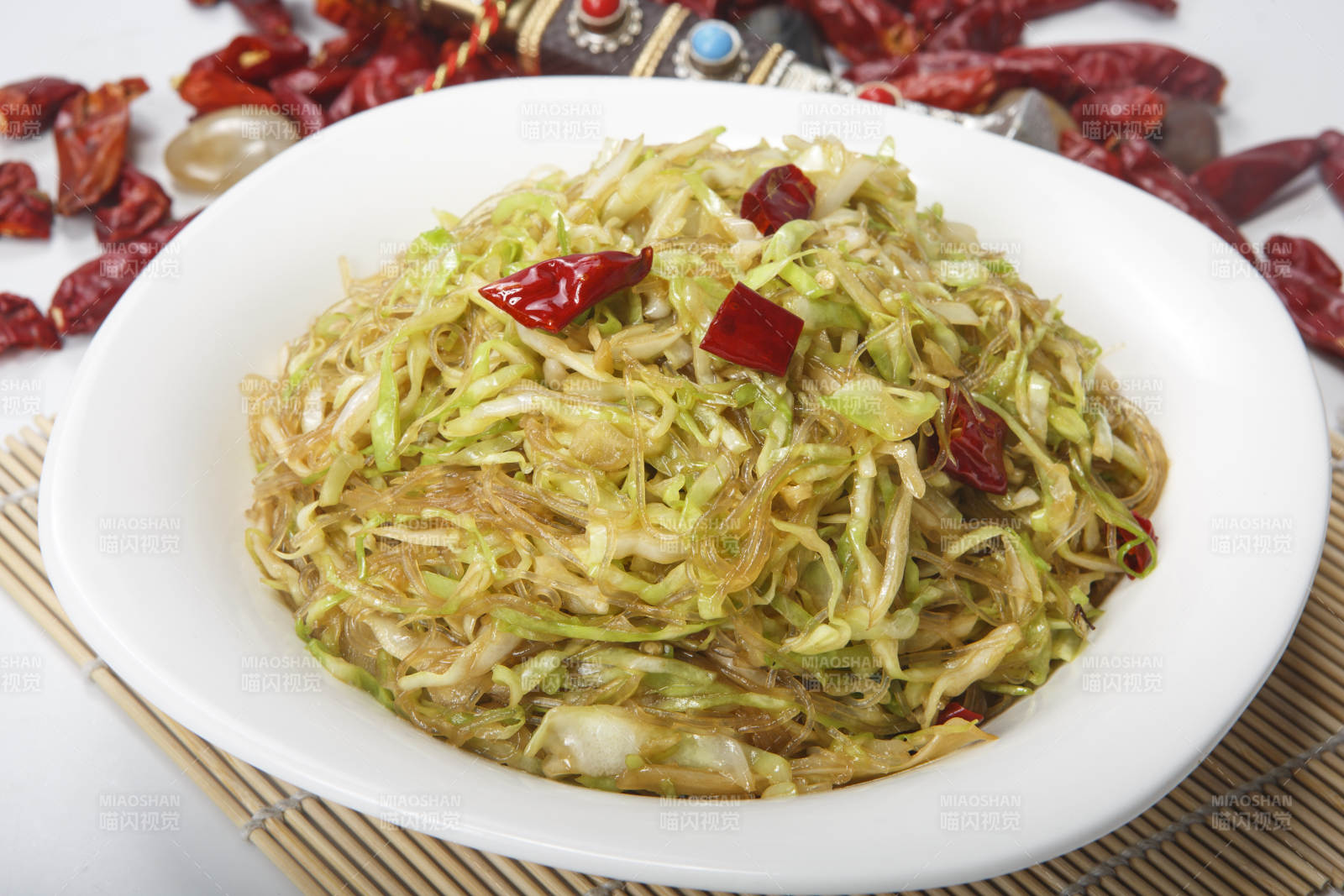 白瓷盘装的粉丝炒包菜图片