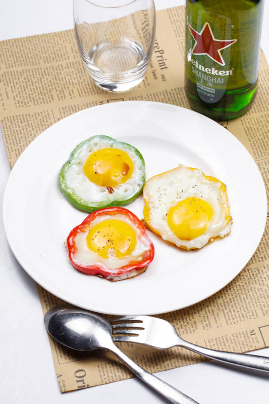 白色瓷盘装的彩椒香煎太阳蛋图片