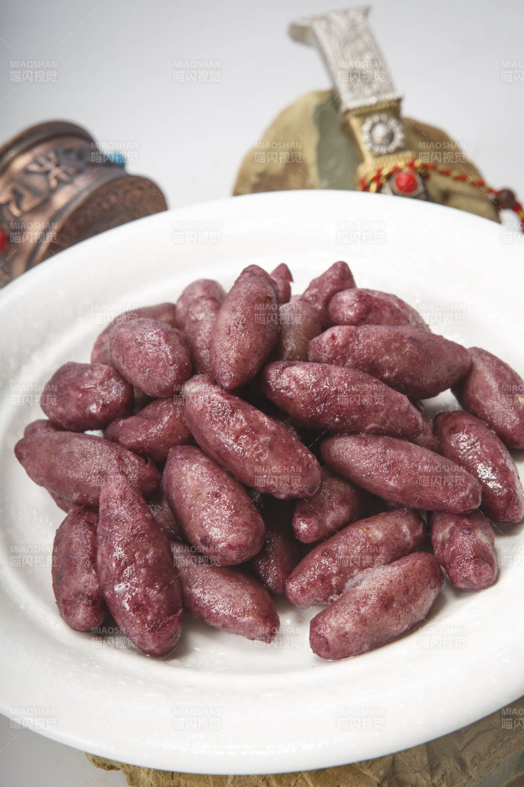 白色圆瓷盘装的蜜醸小紫薯图片