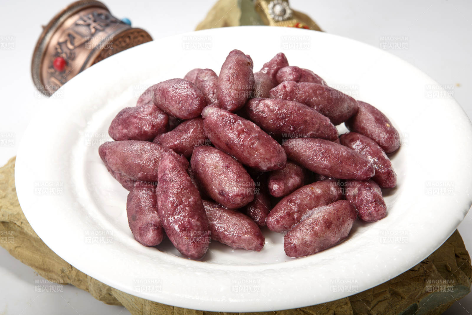 白色圆瓷盘装的蜜醸小紫薯图片