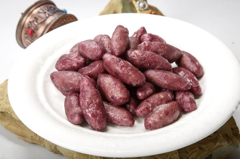 白色圆瓷盘装的蜜醸小紫薯图片