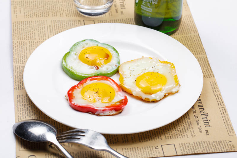 白色瓷盘装的彩椒香煎太阳蛋图片