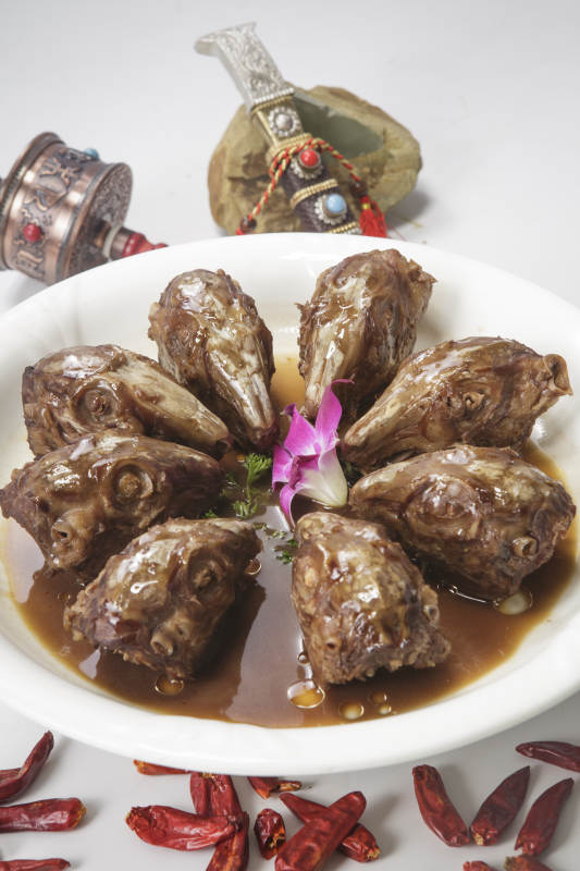 圆形白瓷盘装的麻辣兔头图片