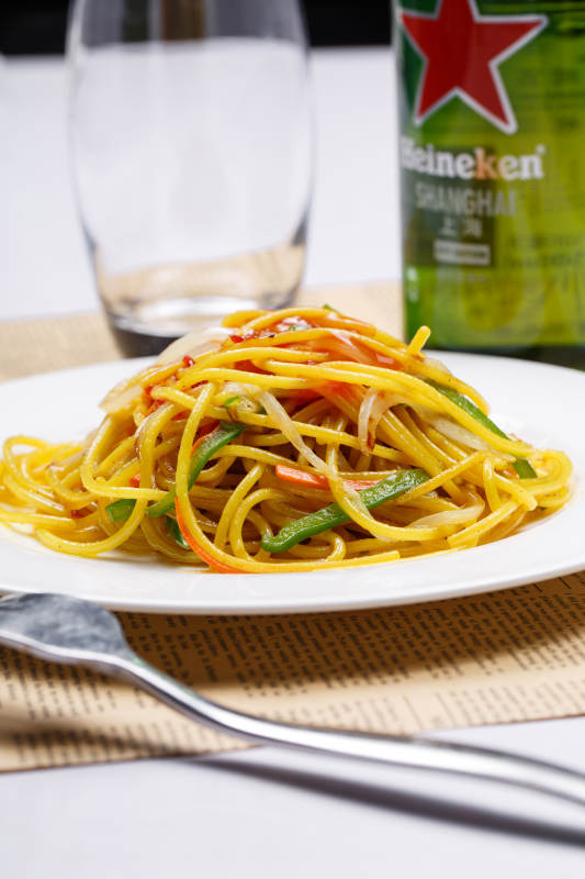 白色瓷盘装的番茄肉酱炒意面图片