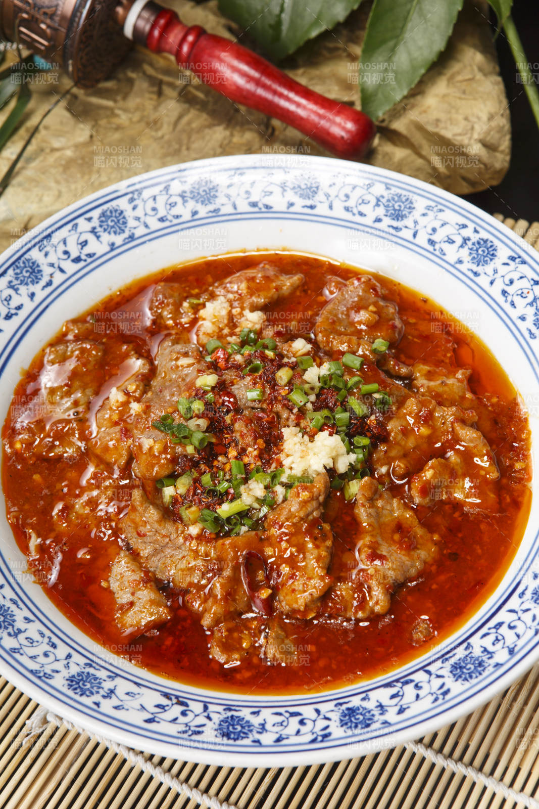 青花瓷盘装的麻辣水煮牛肉图片