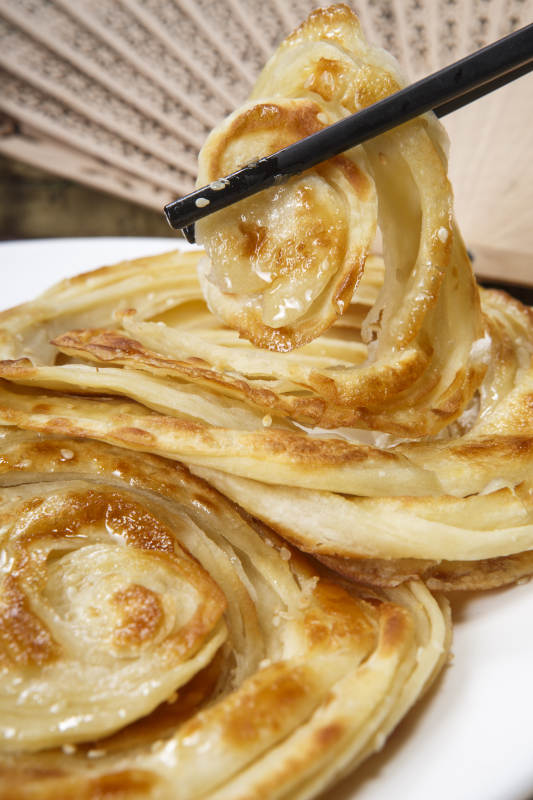 白色圆盘装的葱油饼图片