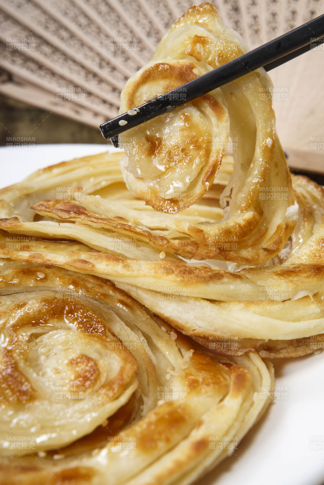 白色圆盘装的葱油饼图片