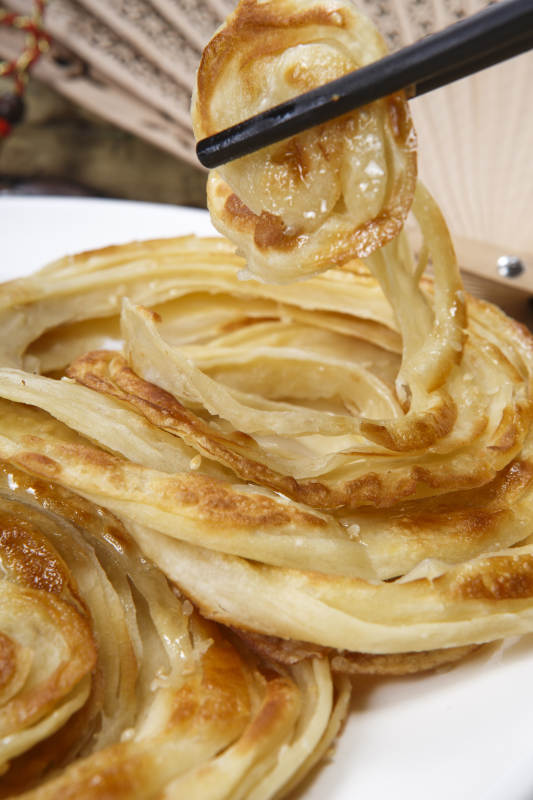 白色圆盘装的葱油饼图片