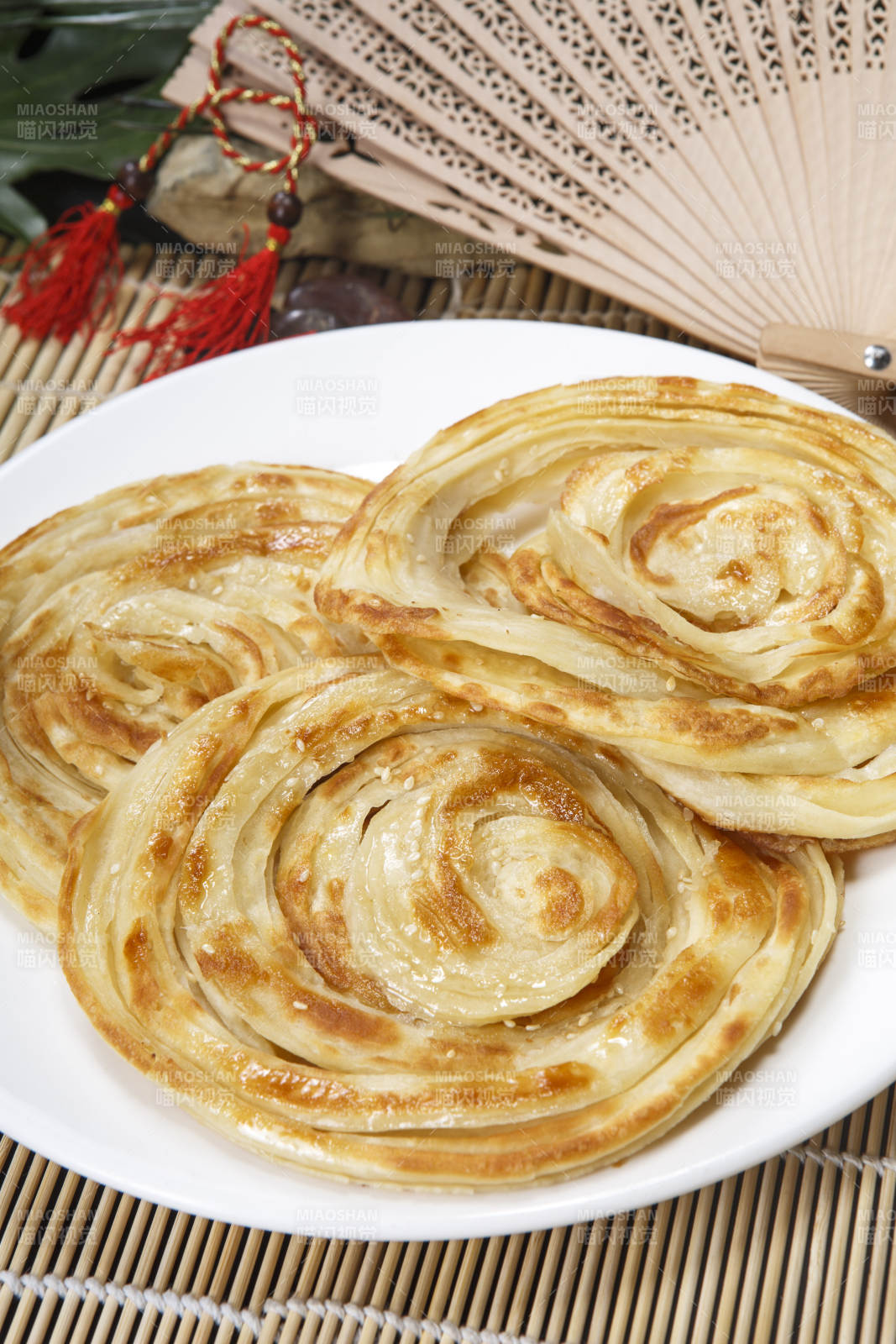 白色圆盘装的葱油饼图片