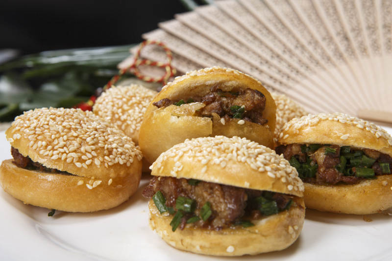 白色瓷盘装的酱肉锅盔图片