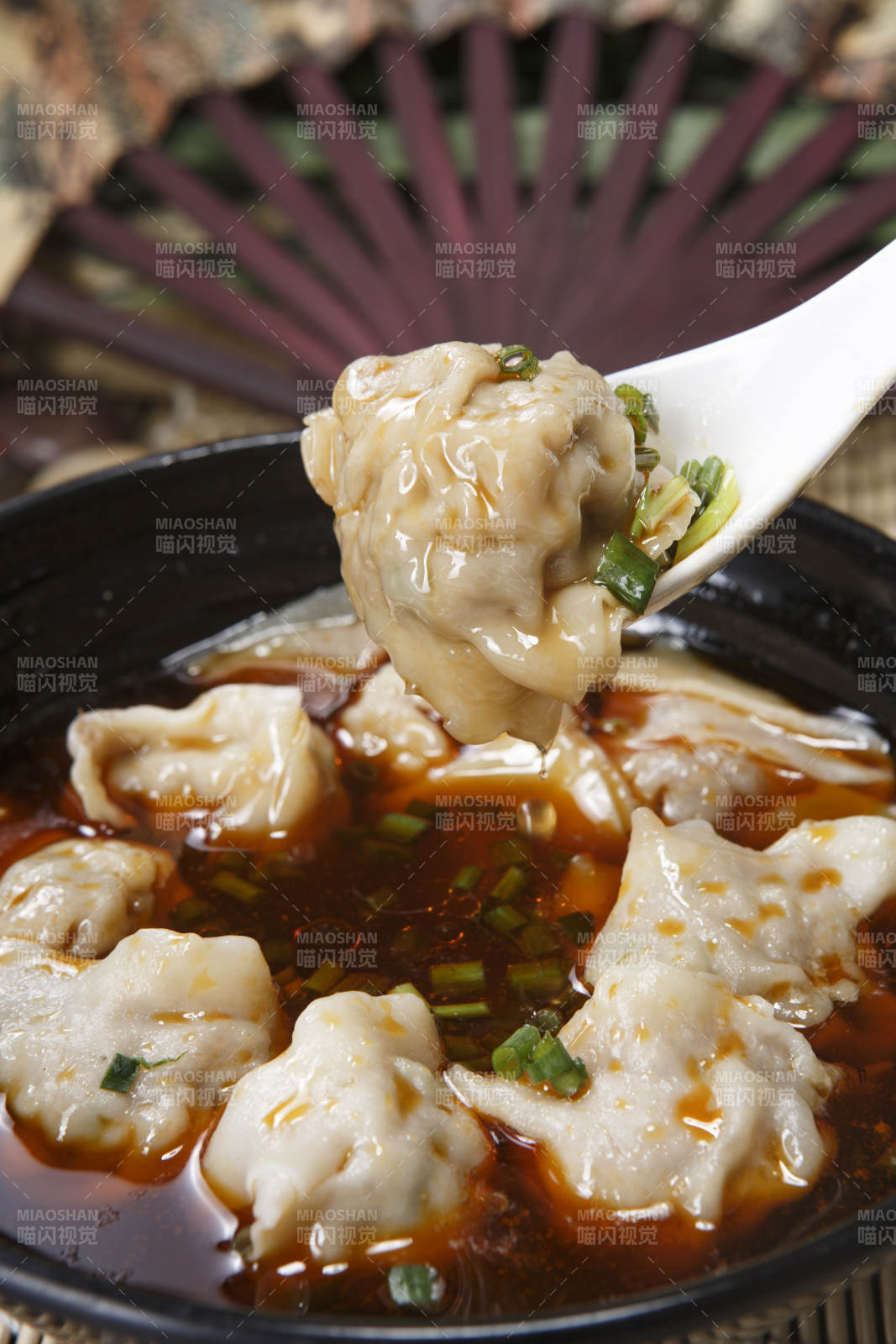 黑色瓷碗装的红油抄手馄饨图片