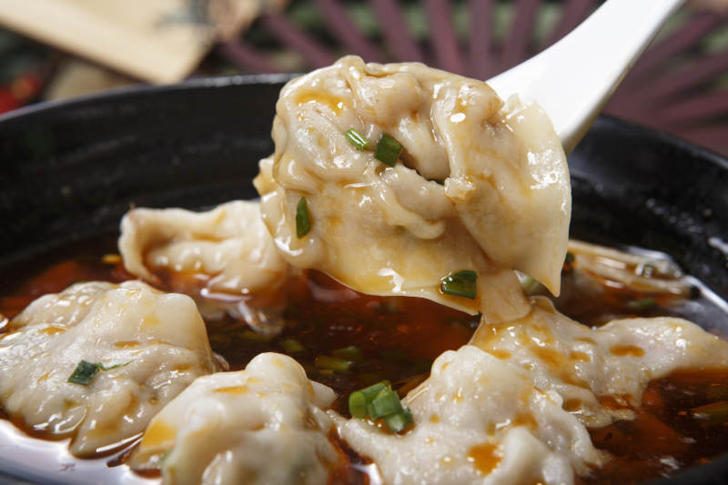 黑色瓷碗装的红油抄手馄饨图片