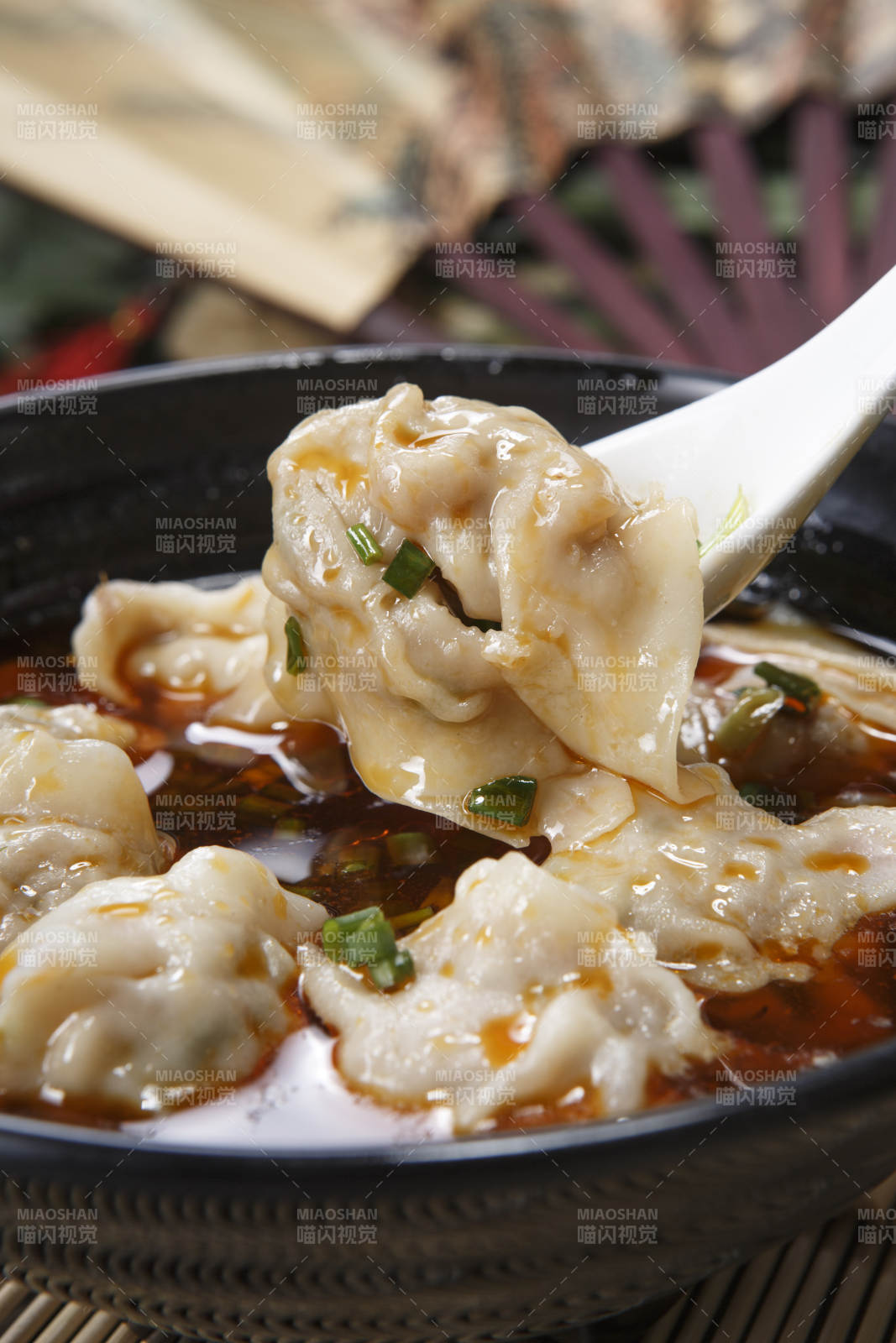 黑色瓷碗装的红油抄手馄饨图片