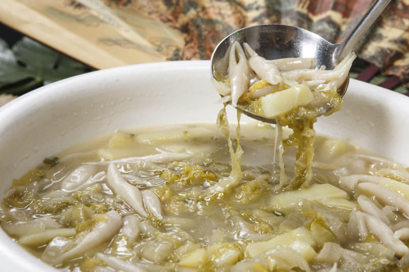 白色圆瓷盆装的酸菜土豆生下鱼图片