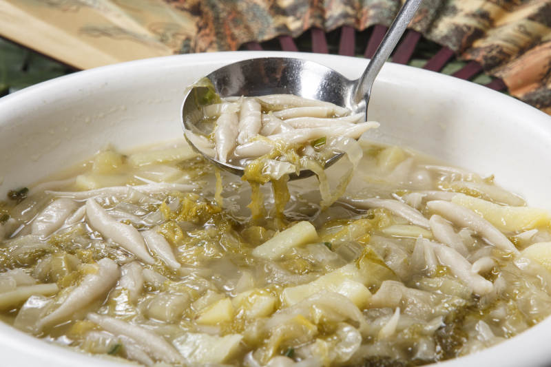 白色圆瓷盆装的酸菜土豆生下鱼图片