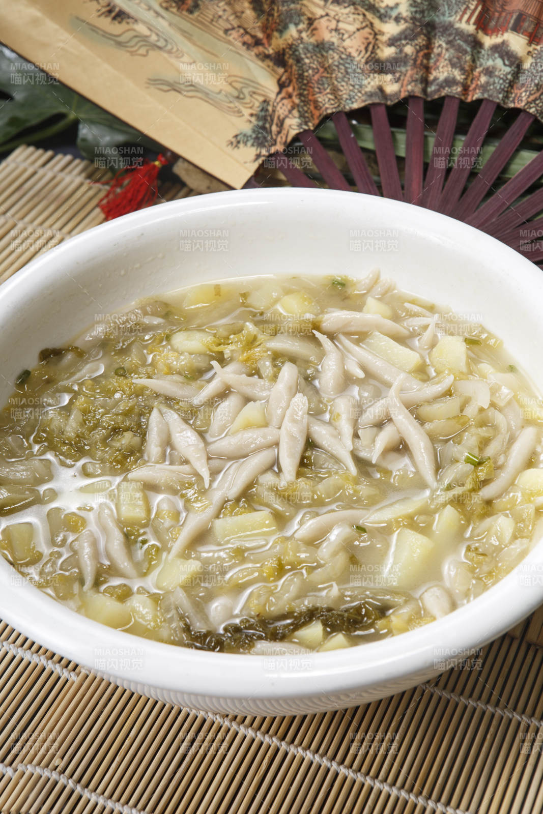 白色圆瓷盆装的酸菜土豆生下鱼图片