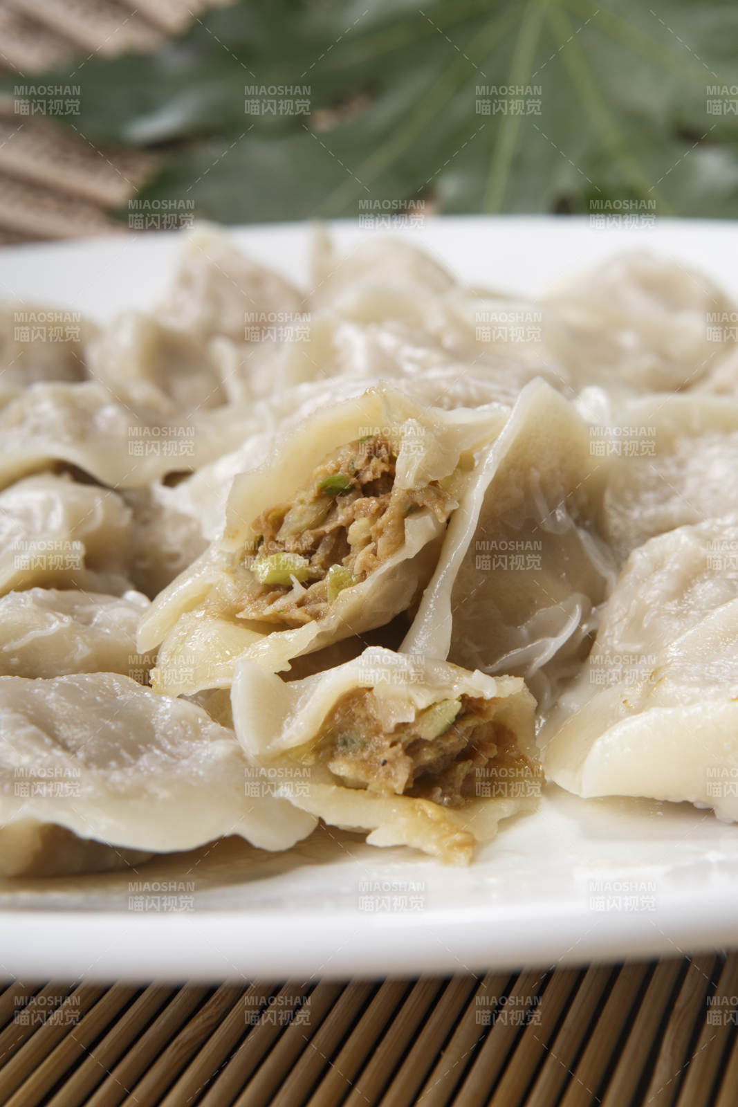 刚出锅的猪肉大葱饺子摆放在白色背景上图片