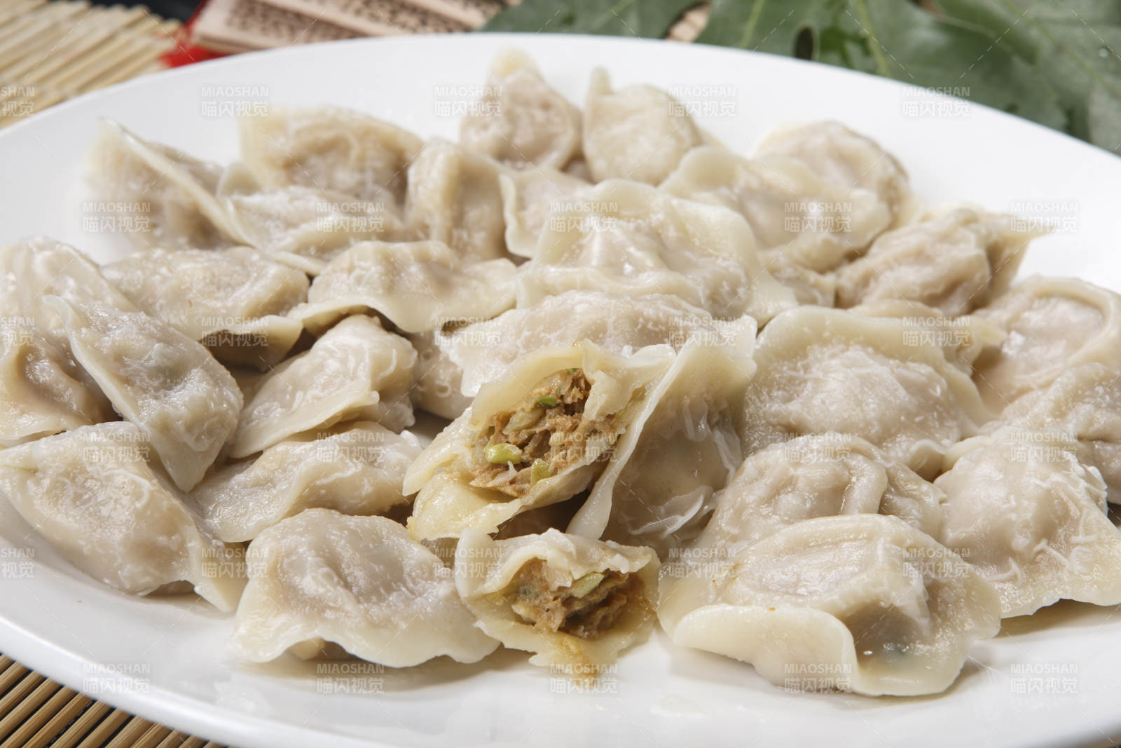 刚出锅的猪肉大葱饺子摆放在白色背景上图片